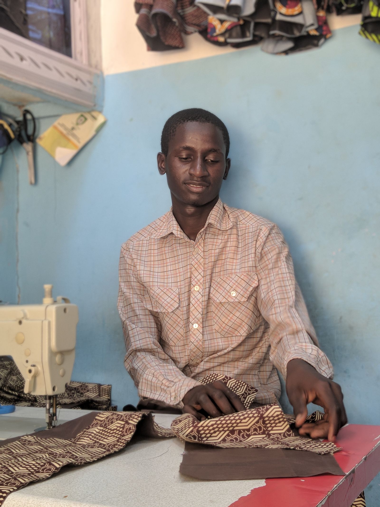 A tailor working with patterned fabric in Maiduguri, Nigeria